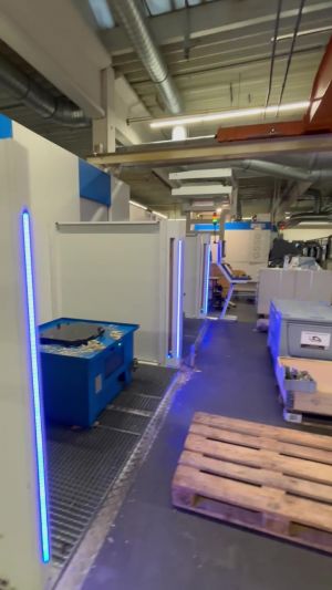 Moderner industrieller Werkstattbereich mit Ausrüstung und blauer Neonbeleuchtung