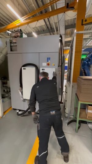 Technician Operating Industrial Equipment in a Modern Factory Setting