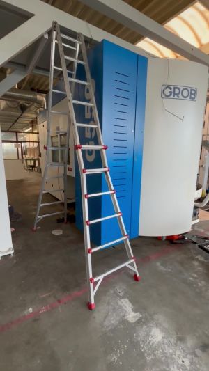 Aluminum Ladder Near Industrial Machine in Manufacturing Facility Setting