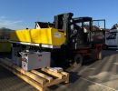 Forklift Transporting Heavy Machinery in an Industrial Outdoor Setting