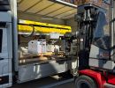 Forklift Loading Equipment Into Open Delivery Truck with Blue Sky Background
