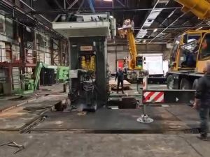 Aufbau von Industriemaschinen in einer Fabrik mit Arbeitern und schweren Geräten