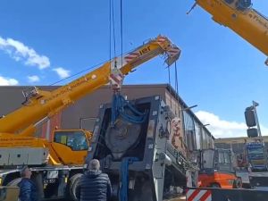 Große Industrieausrüstungen werden auf einer Baustelle von Kränen angehoben