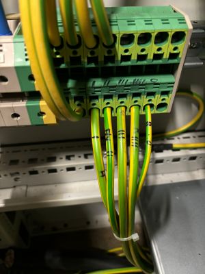 Yellow and Green Electrical Wires Connected to Terminal Block in Electrical Panel