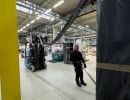 Worker Operating Forklift in a Busy Industrial Warehouse Factory Setting