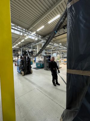 Worker Operating Forklift in a Busy Industrial Warehouse Factory Setting