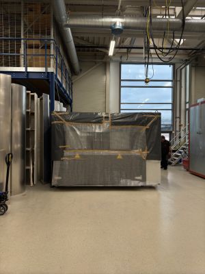 Industrial Workshop Interior Showing Equipment and Large Wrapped Object Under Storage