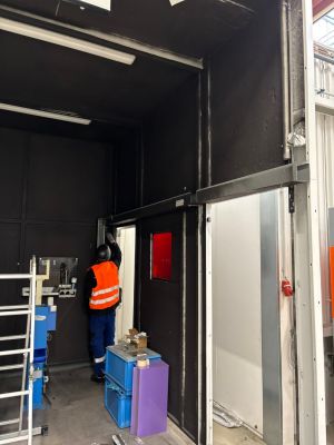 Worker Adjusting Door Frame in a Modern Industrial Workshop Setting