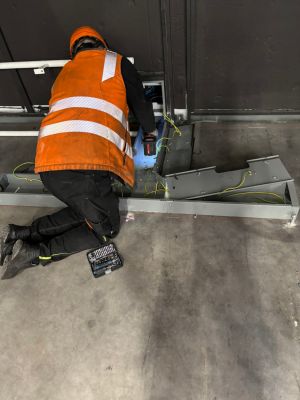 Worker Performing Maintenance on Electrical Equipment in Industrial Setting