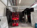 Red Scissor Lift in a Warehouse Under Construction With Exposed Ceiling Structures