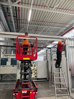 Workers Utilizing Elevated Platforms in a Spacious Industrial Facility