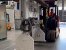 Worker Operating Forklift to Move Machinery in Industrial Facility