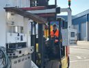 Worker Operating Forklift in Industrial Area Handling Heavy Machinery