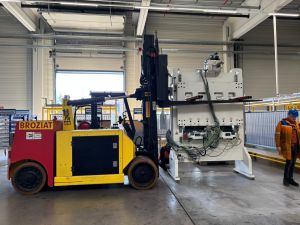 Heavy Equipment Forklift Transporting Industrial Machinery in a Warehouse Setting