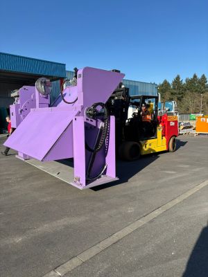 Forklift Transporting Large Purple Industrial Machine in Outdoor Factory Area