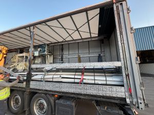 Industrial Loading Setup Inside Open-Walled Truck Near Warehouse Facility
