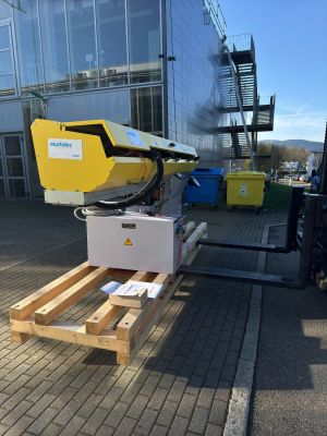 Gelbe Industrieausrüstung auf Holzpalette im Freien in der Nähe eines modernen Gebäudes