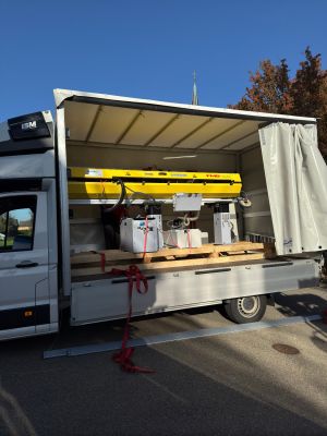 Lieferwagen beim Transport von Maschinen an einem klaren, sonnigen Tag im Freien