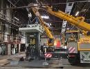 Industrial Crane Lifting Heavy Machinery Inside a Spacious Factory Workshop
