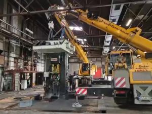 Industrial Crane Lifting Heavy Machinery Inside a Spacious Factory Workshop