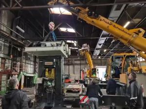 Industrial Equipment Installation Using Crane in a Warehouse Setting