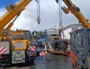 Heavy Equipment Lifting by Dual Cranes at a Construction Site