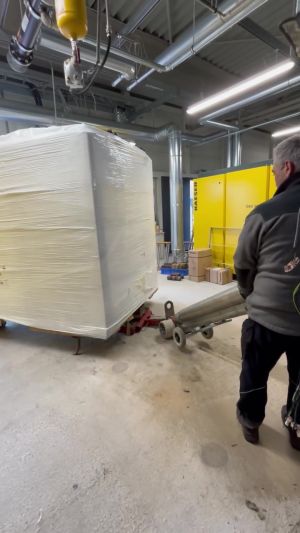 Arbeiter, der in einem Industrielager beim Transport von Schwerlastgütern Geräte benutzt