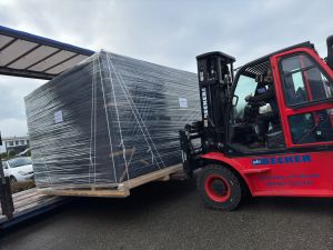 Gabelstapler, der ein verpacktes Frachtpaket für den Transport auf einen Lkw lädt