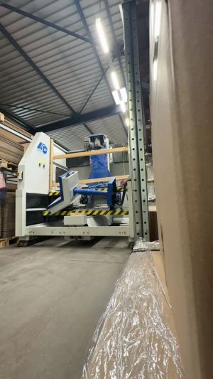 Industriemaschinen im Lager mit gestapelten Materialien und Schutzabdeckungen